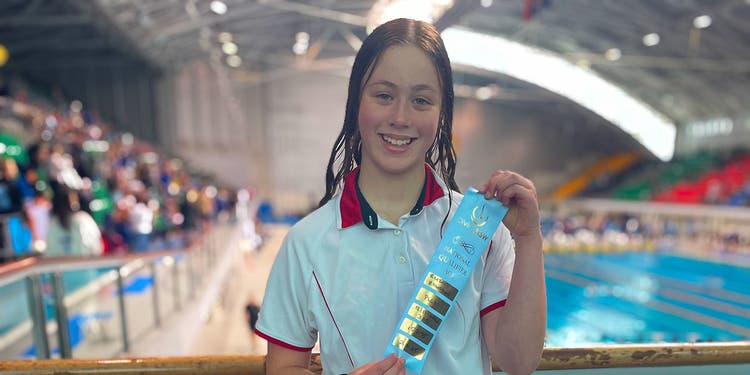 photo of student holding award ribbon at pool