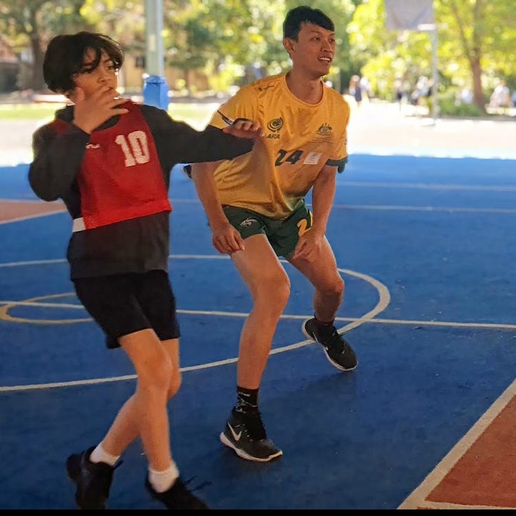 student and frisbee pro on the oval