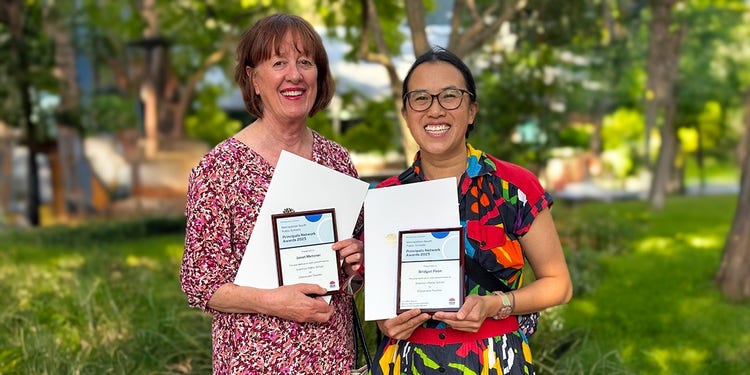 photo of two teachers holding awards