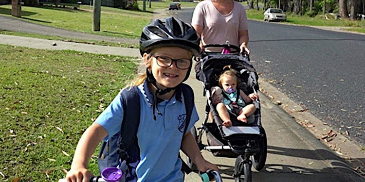Girl on a bike cycling to school