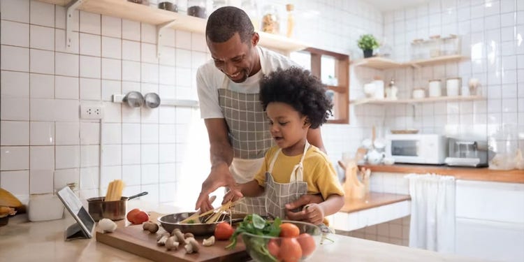 father and child cooking together in a bright kitchen