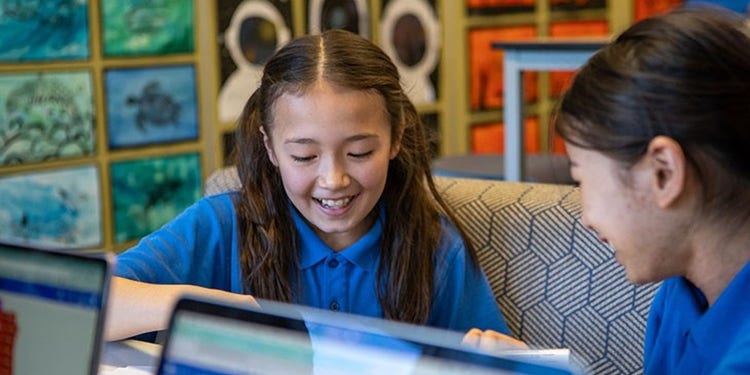two girls sitting together smiling